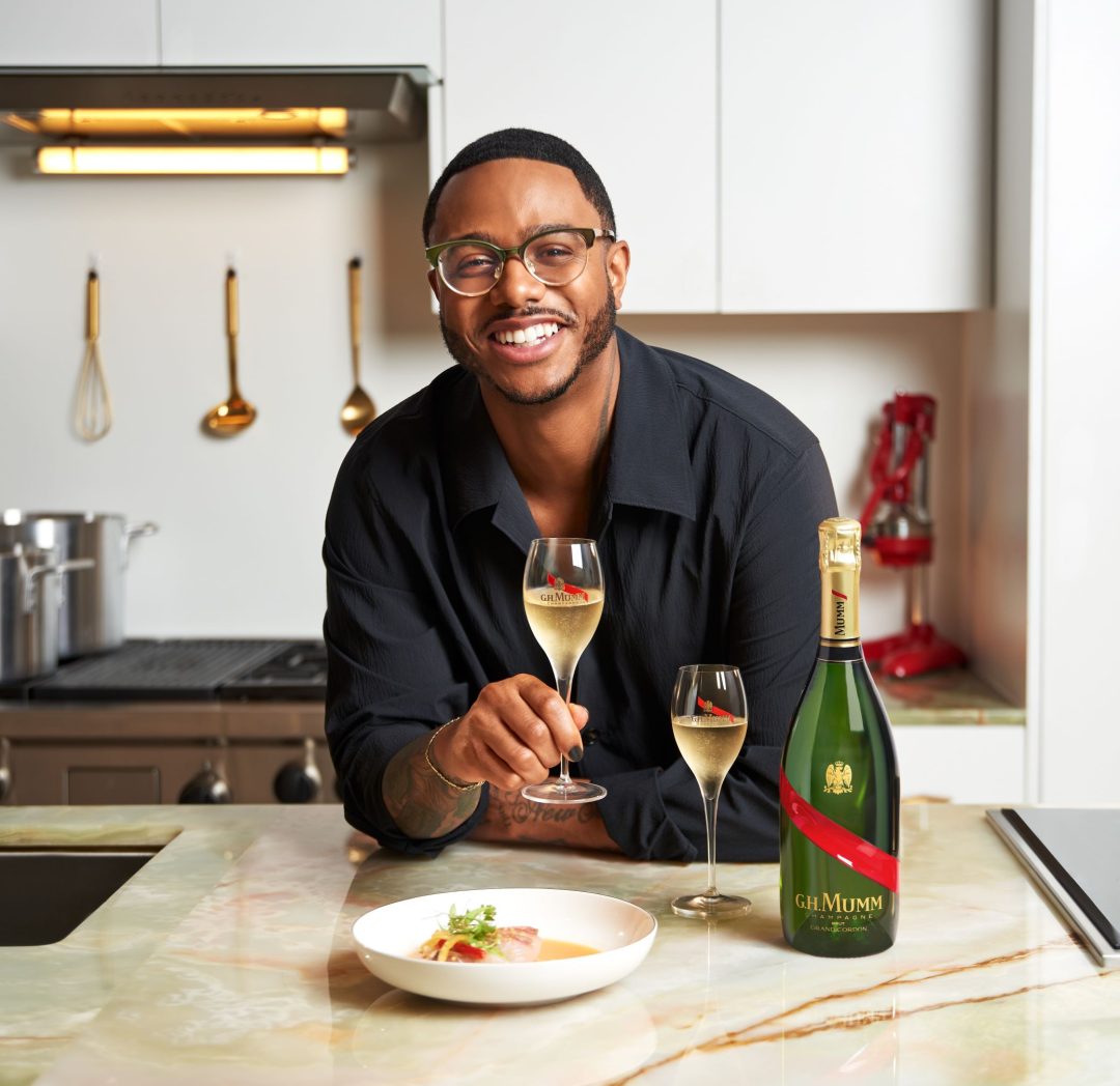 Chef Kwame holding a glass of GH Mumm
