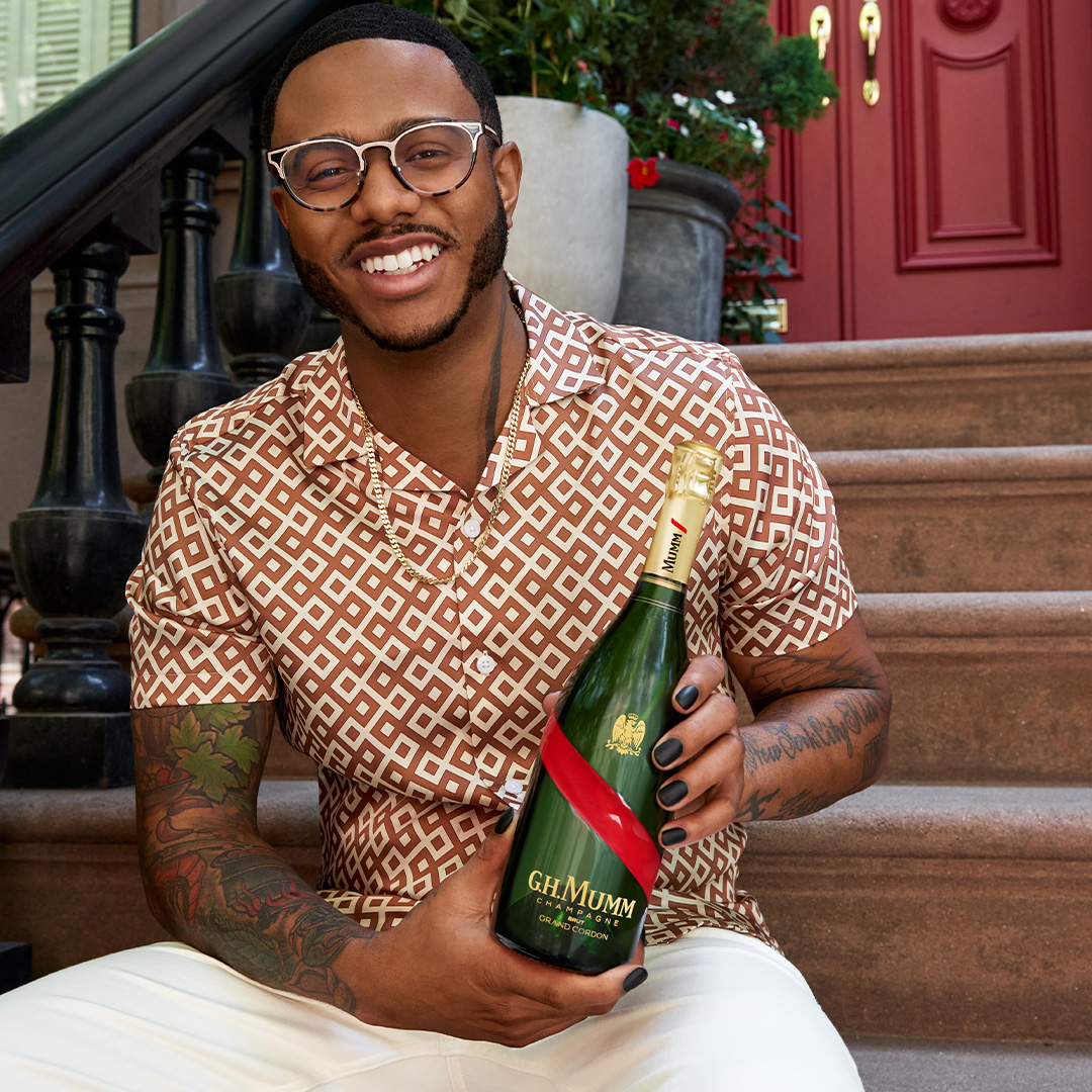 Chef Kwame holding a GH Mumm Champagne bottle