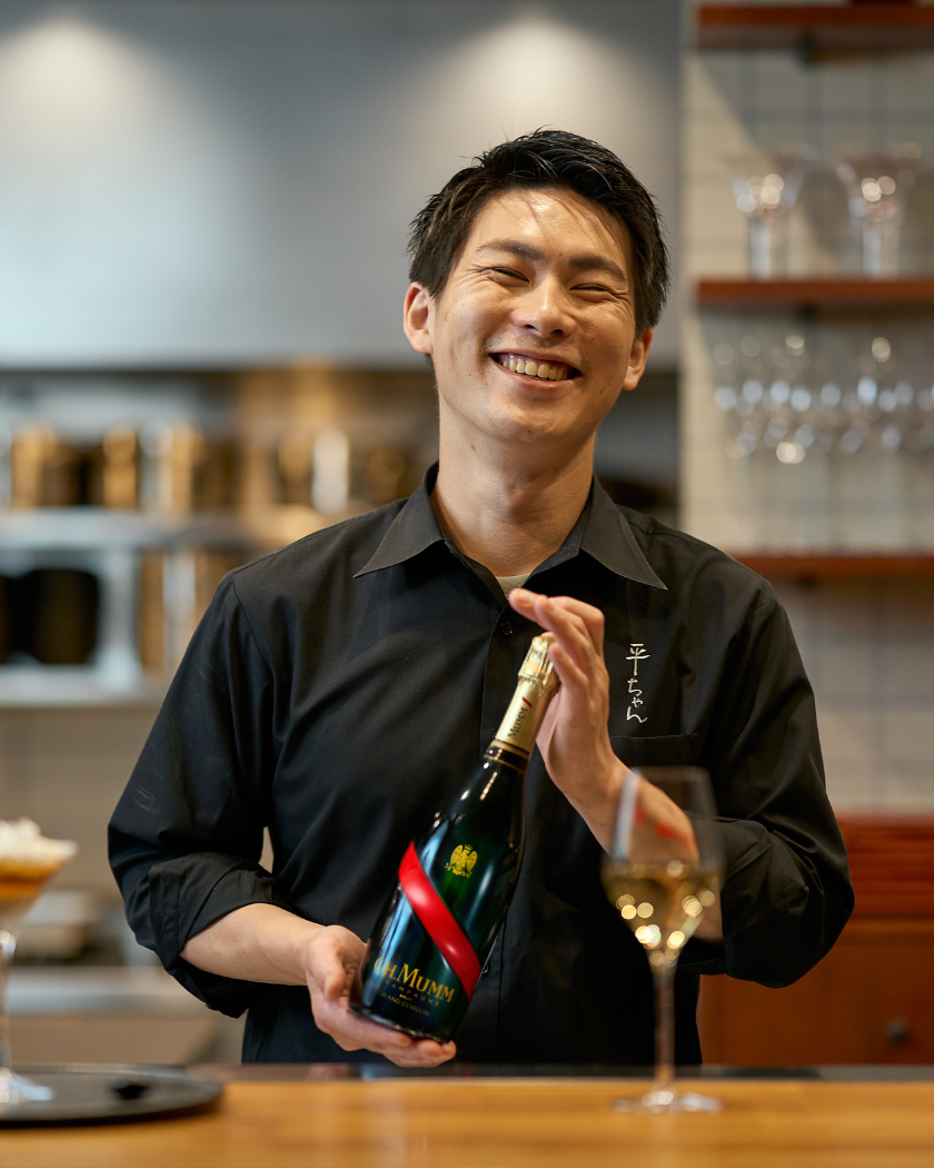 Chef yamato Konnai holding grand cordon brut champagne bottle