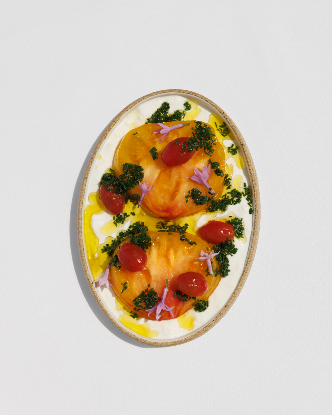 Tomates antiguos, cerezas frescas y ricotta batida con aceite de albahaca