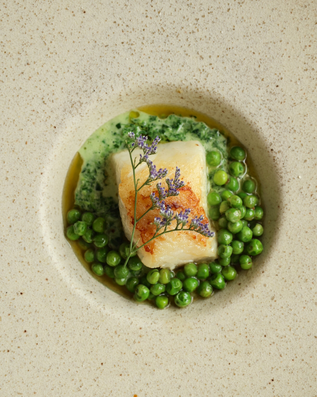 Pan-seared Cape hake, lemony morogo cream, fresh peas & spring onion oil
